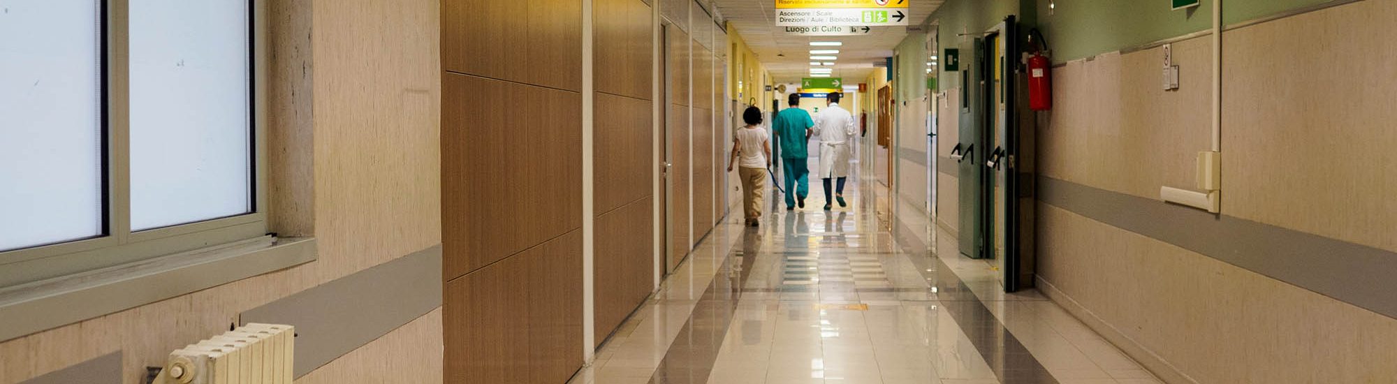 Cisanello, PI, Italy - June 13th 2025 a bright hospital corridor with doctors and nurses walking down the hallway representing healthcare services infrastructure patient care and medical emergencies